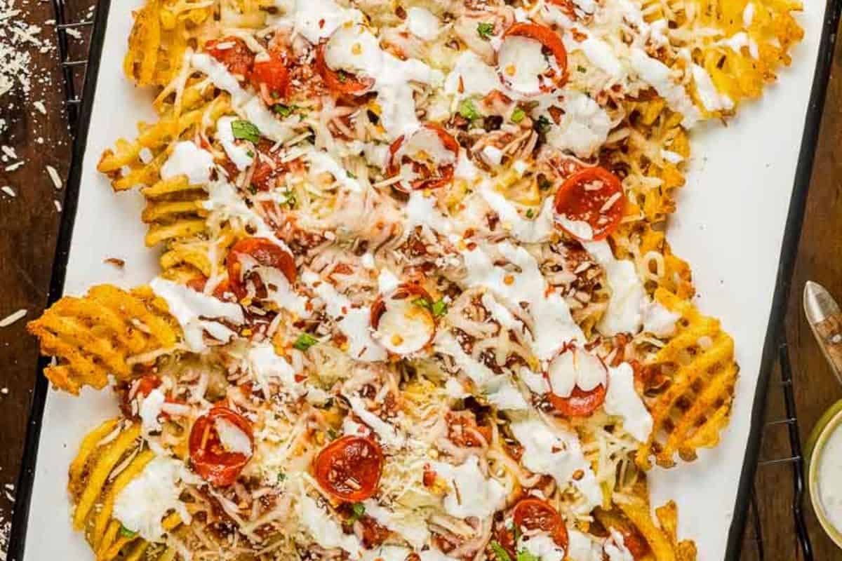 Waffle fries topped with melted cheese, mini pepperoni slices, herbs, and a drizzle of white sauce—this crazy good snack is a must-try for fans of bold flavor.