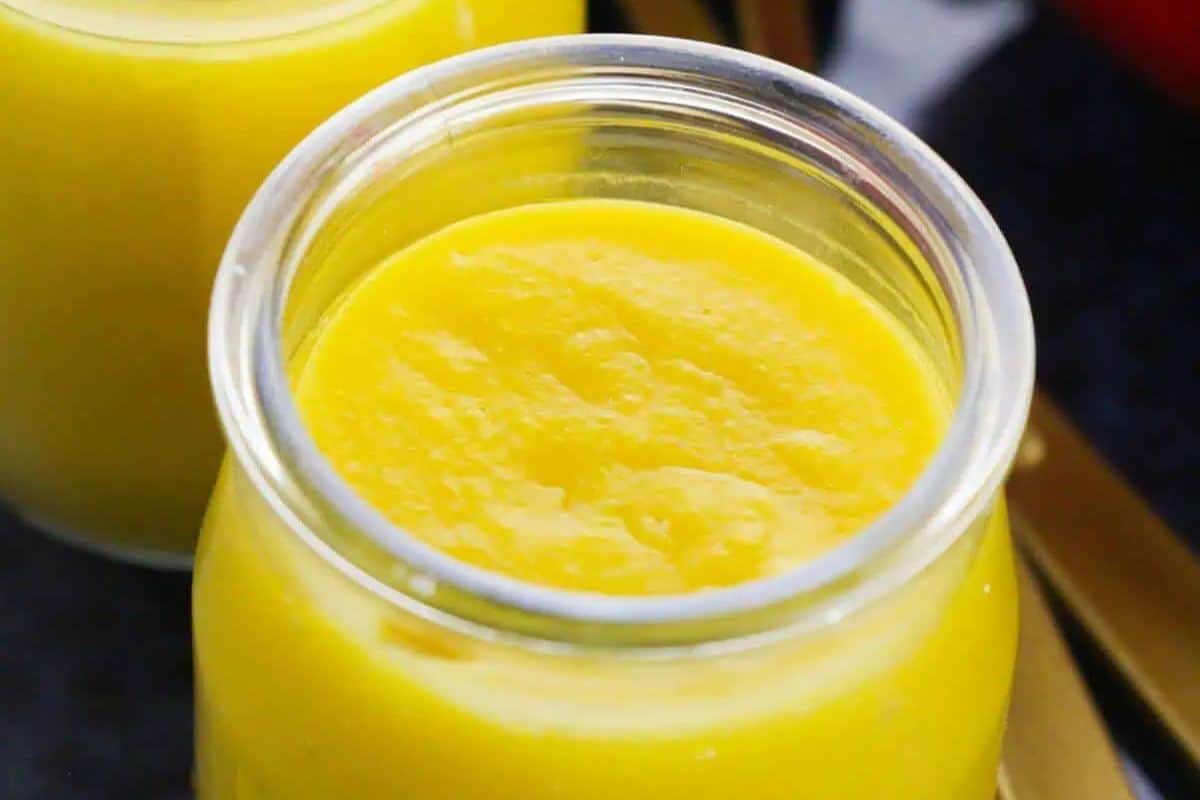 Close-up of a jar of yellow mango pudding.
