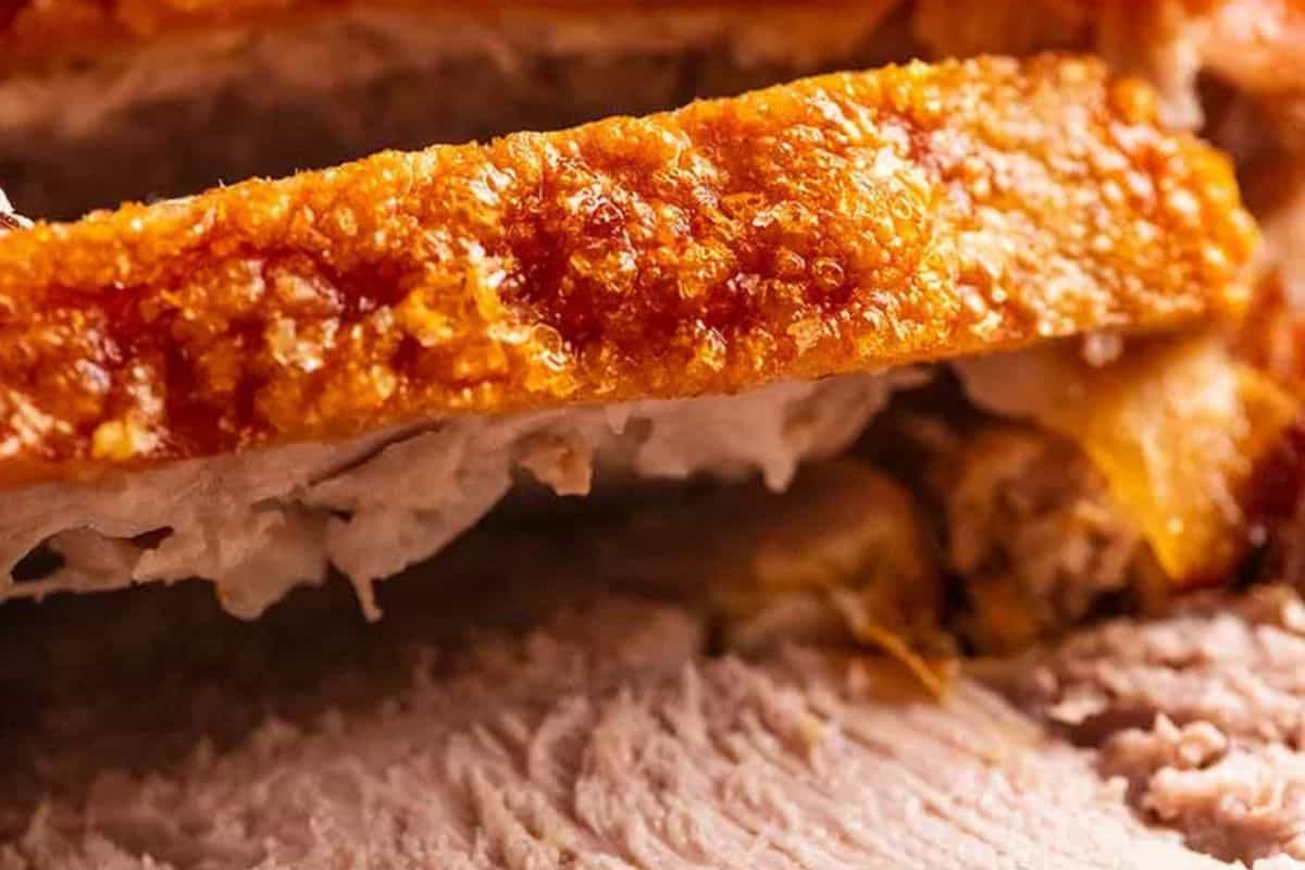 Close-up of crispy pork crackling on top of tender pork meat—a mouthwatering highlight for any Pork Roast or those seeking Delicious Pork Recipes.