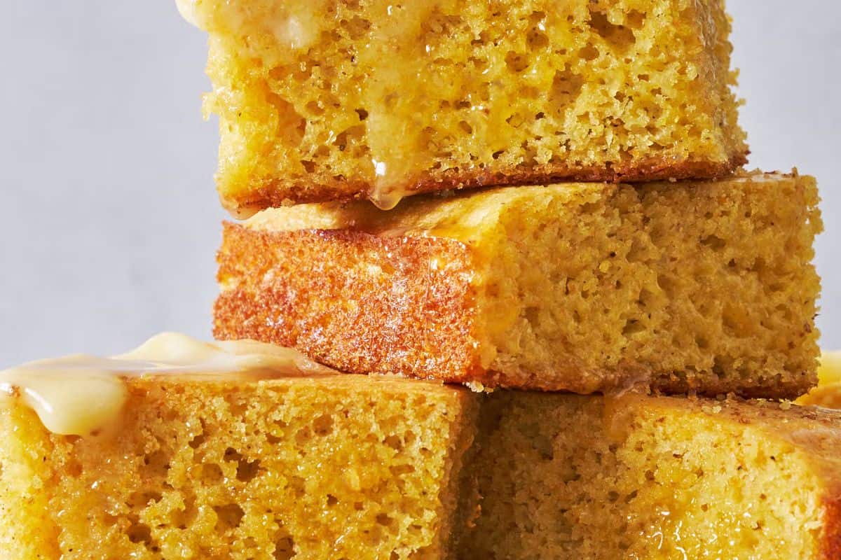 Four pieces of cornbread, one of the must try quick breads, are stacked on top of each other and drizzled with melted butter—perfect to bake anytime.