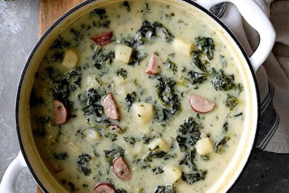 Creamy soup with sliced kielbasa, tender potatoes, and vibrant kale leaves.