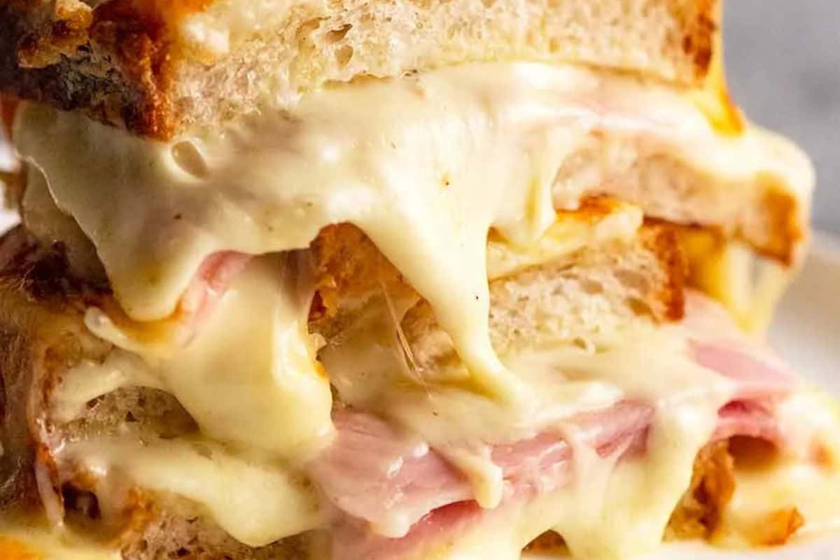 A close-up of a grilled ham and cheese sandwich with melted cheese oozing between slices of toasted bread—one of the most attractive sandwiches from our tasty sandwiches selection.