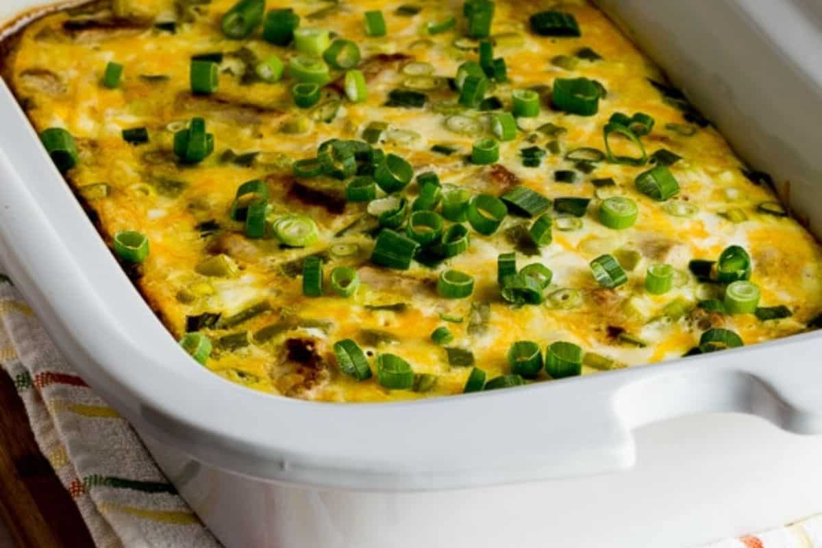 A baked egg casserole topped with chopped green onions in a white rectangular baking dish—perfect for breakfast recipes that make busy mornings easier.