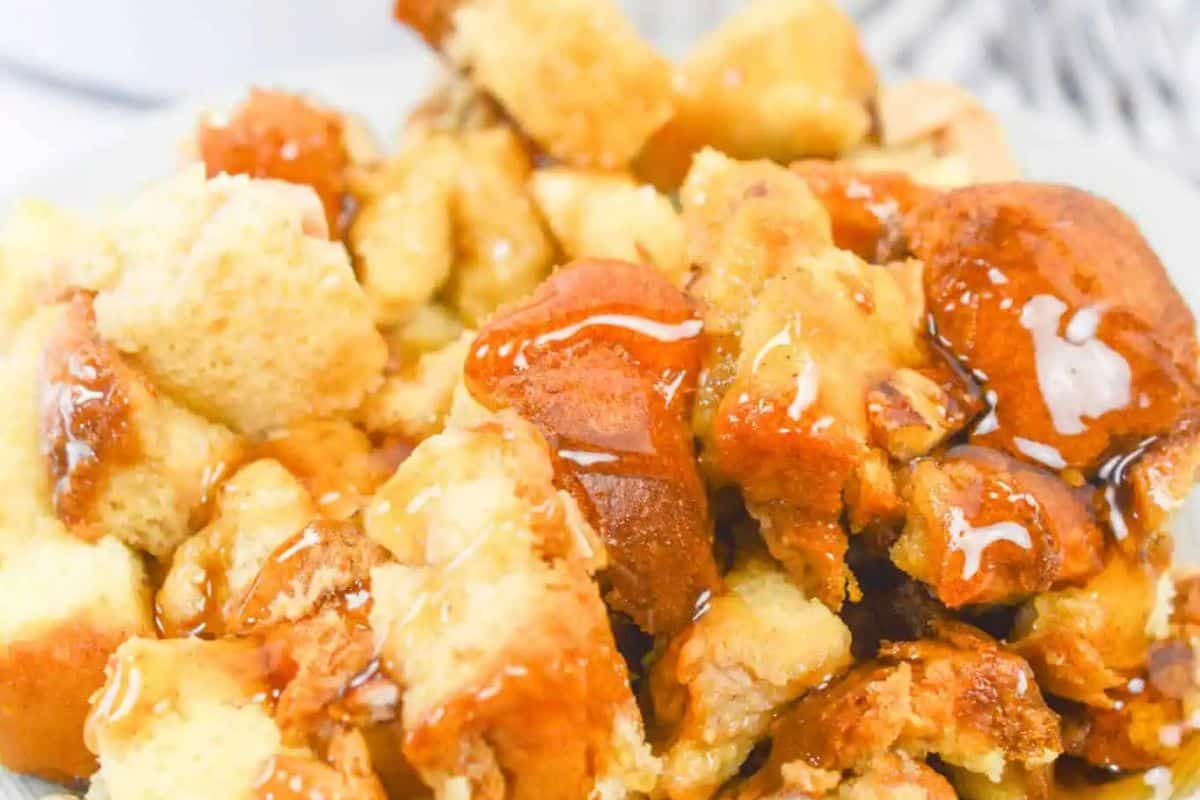 Close-up of bread pudding cubes drizzled with caramel sauce on a plate—a must try for slow cooker breakfasts or busy mornings.