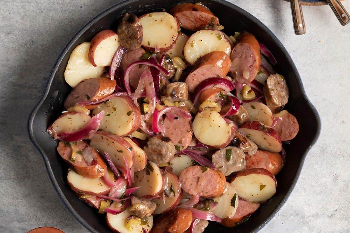 Creamy Polish potato salad with diced potatoes, hard-boiled eggs, pickles, and fresh herbs.