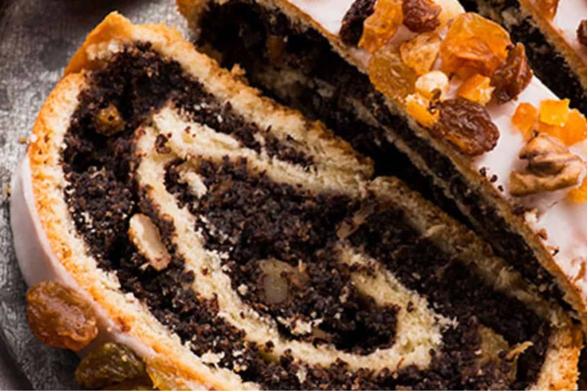 A sweet yeast roll filled with poppy seed paste and sliced to show its swirled interior.