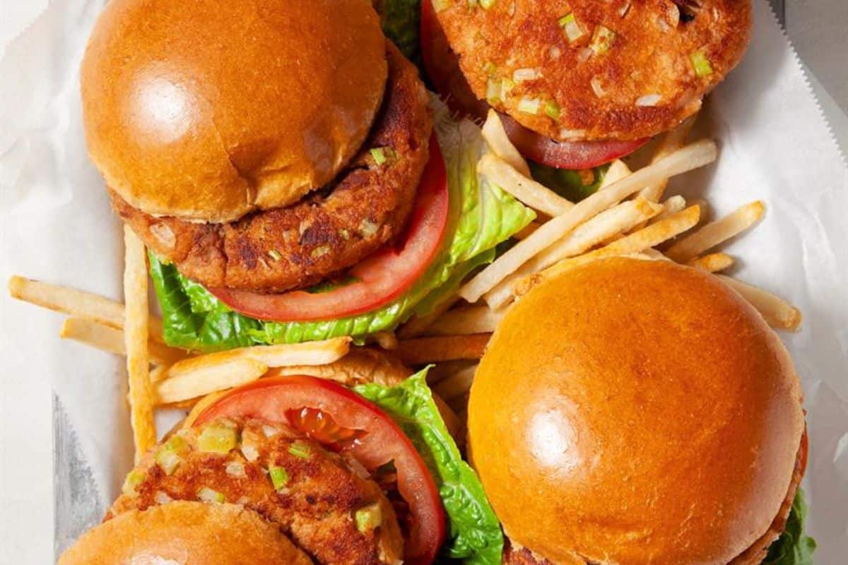 Four veggie burgers with lettuce and tomato on buns, served with a side of French fries—perfect for pairing with easy tuna meals or your favorite canned tuna dinner.
