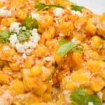 A plate with kernels, crumbled cheese, chopped cilantro, and seasoning sprinkled on top—just like the flavors in a classic bake.