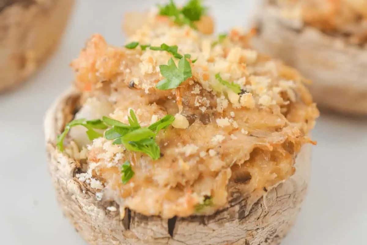 A close-up of a stuffed mushroom cap topped with breadcrumbs and garnished with chopped parsley, perfect for anyone searching for delicious Stuffed Mushroom Recipes.