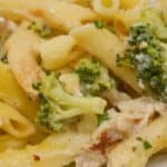 A close-up of a plate of Baked Chicken and Broccoli Alfredo featuring penne pasta, tender broccoli florets, juicy chicken pieces, and a creamy sauce.