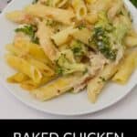 A white plate of Baked Chicken and Broccoli Alfredo pasta sits on the table, featuring penne, fresh broccoli, and creamy sauce, with a fork and parsley garnish nearby.