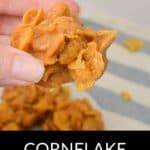A hand holding a cluster of Cornflake Cookies with a glossy, caramel-like coating; more Cornflake Cookies are blurred in the background. The text "Cornflake Cookies" is at the bottom.