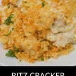 A serving of Ritz Cracker Chicken Casserole with a golden, crumbly topping, garnished with parsley, is presented on a white plate.