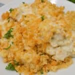A plate of creamy Ritz Cracker Chicken Casserole topped with golden, crispy breadcrumbs and garnished with chopped parsley.