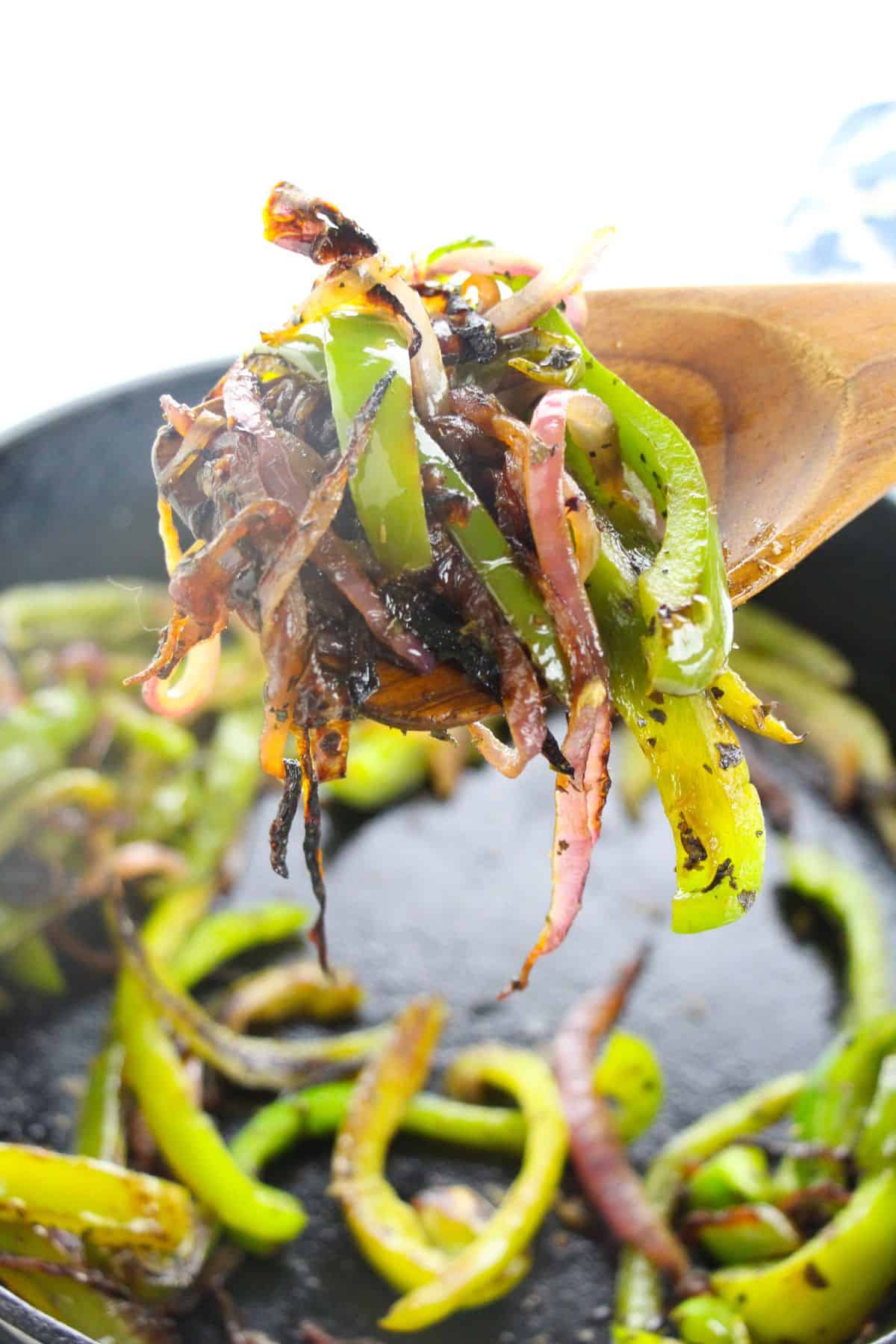 A wooden spoon holds sautéed veggies more tender, colorful vegetables.