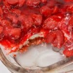 A glass baking dish with a portion missing, revealing inviting layers.