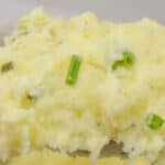 Close-up of creamy Boursin Mashed Potatoes garnished with chopped chives.