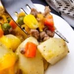 A fork on a plate with ground beef and potatoes.