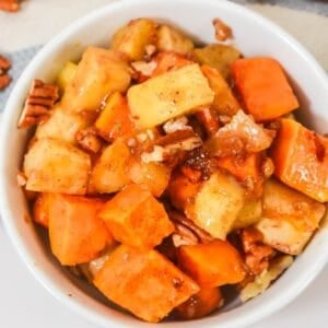 A bowl filled with diced apples, sweet potatoes, pecans, and a cinnamon glaze—perfect for a Sweet Potato Apple Casserole.