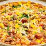 A bowl of chili with beans, corn, ground meat, tomatoes, melted cheese, and chopped herbs. Text at the bottom reads “MUST TRY BEST CHILI RECIPES” — perfect inspiration for anyone searching for the best chili or new chili recipes to try.