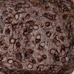 A square topped with chocolate chips, viewed from above on a red and white striped cloth.