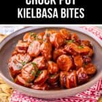 A bowl of sliced Crock Pot Kielbasa sausage coated in a glossy sweet and spicy sauce, served on a patterned red napkin.