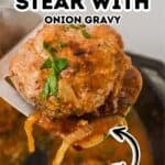 A Hamburger Steak with Onion Gravy, topped with chopped parsley, is lifted on a spatula above a skillet filled with savory onion gravy, while a text overlay highlights the delicious dish.