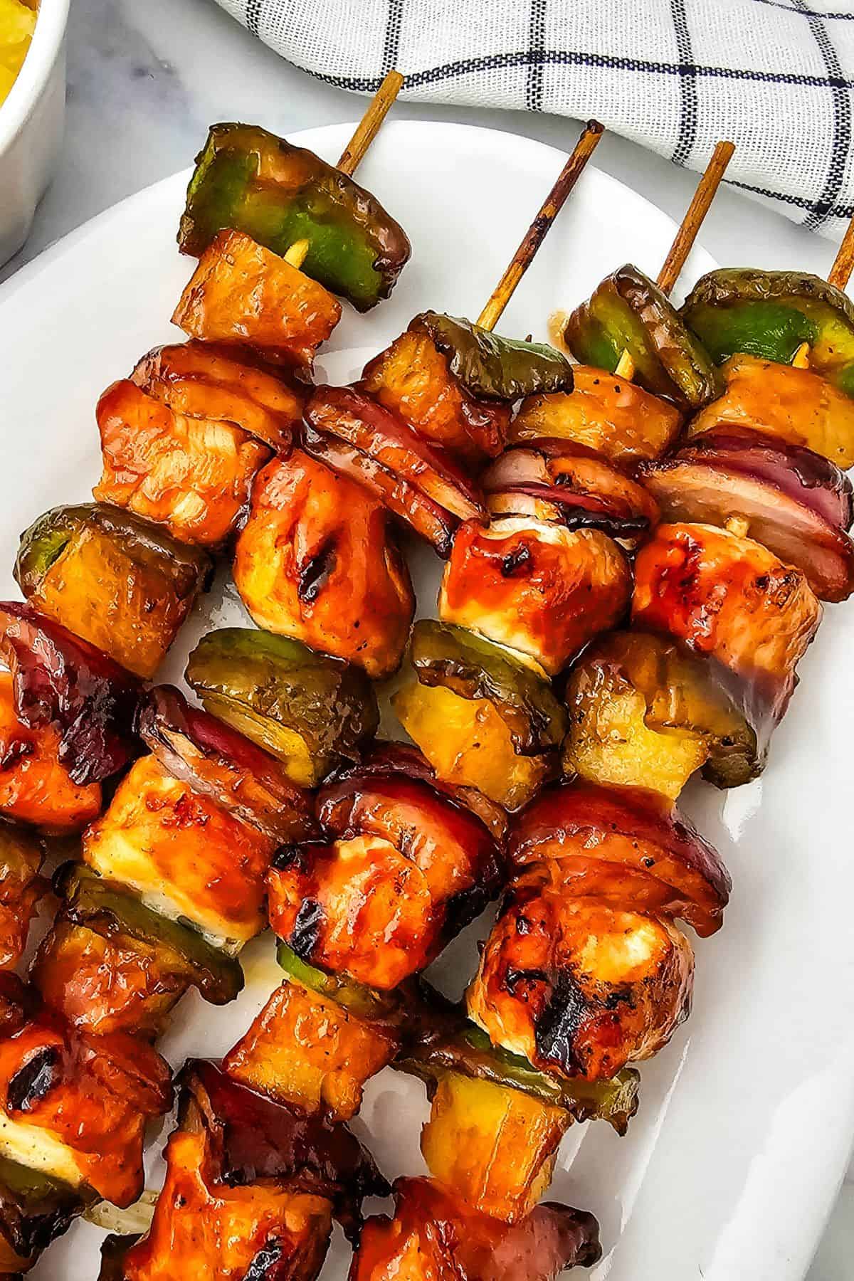 Three skewers on a white plate.
